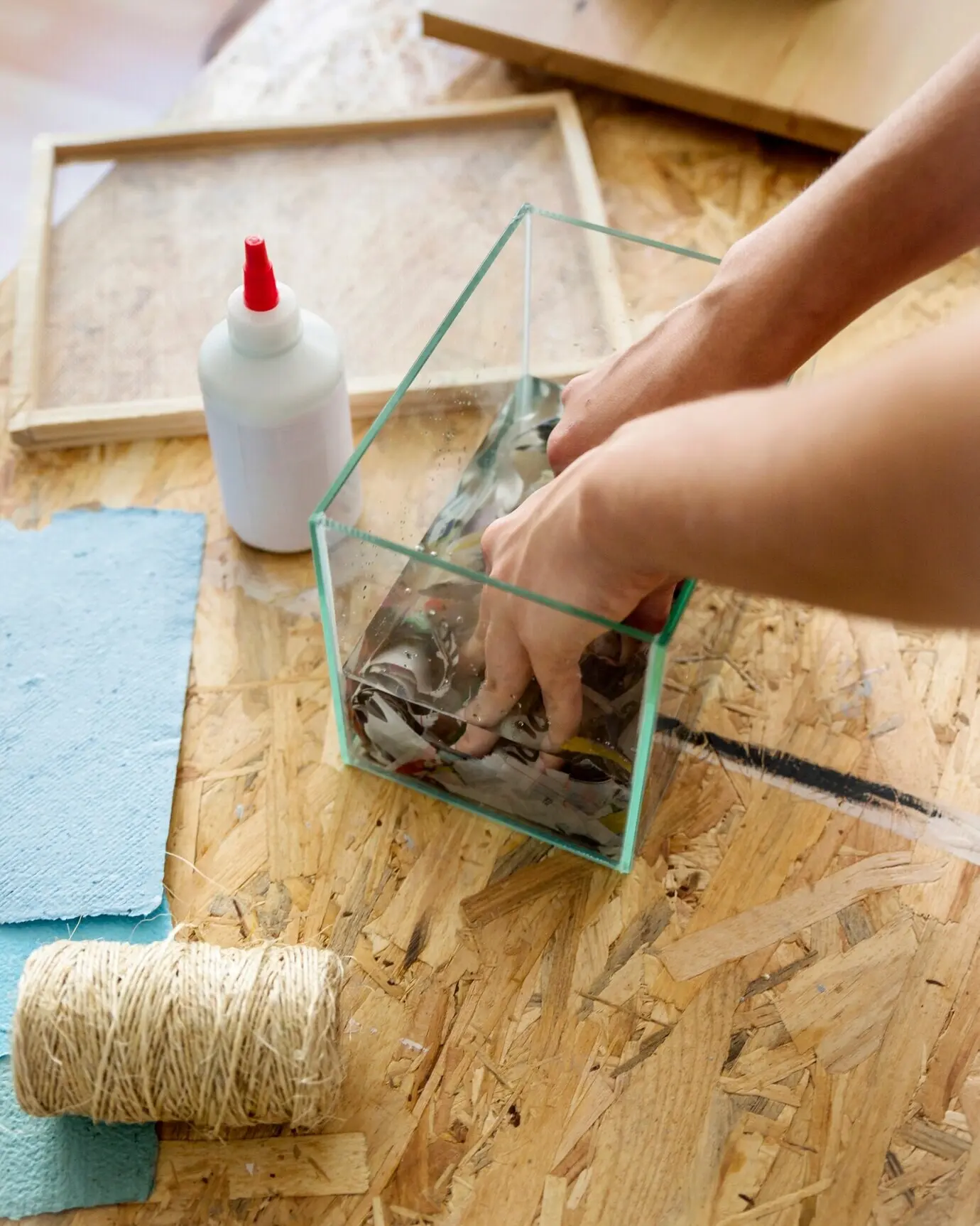 A woman's hand dissolving torn paper in water